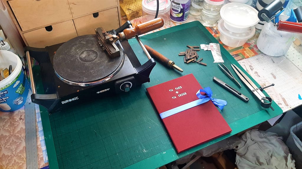 Workbench in bookbindery with book and brass lettering tools