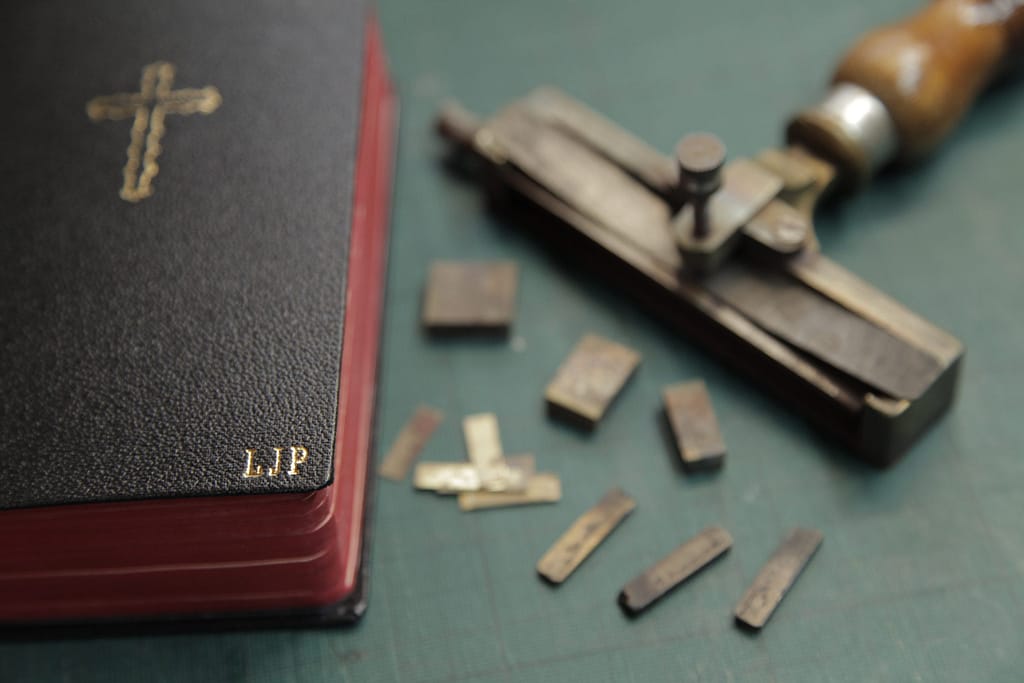Bible with gold cross and monogram letter