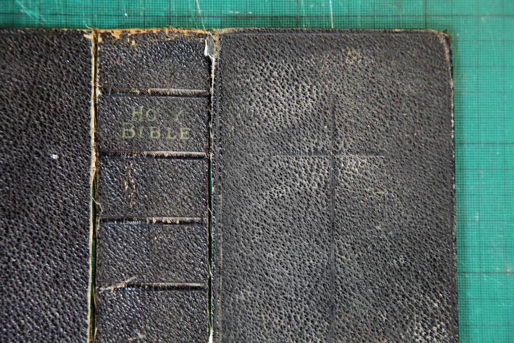 Old bible book cover faded letters plain cross