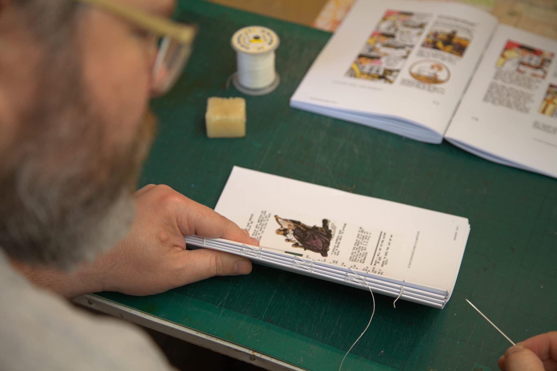 Sewing sections of the My Catholic Library Children's Missal by hand