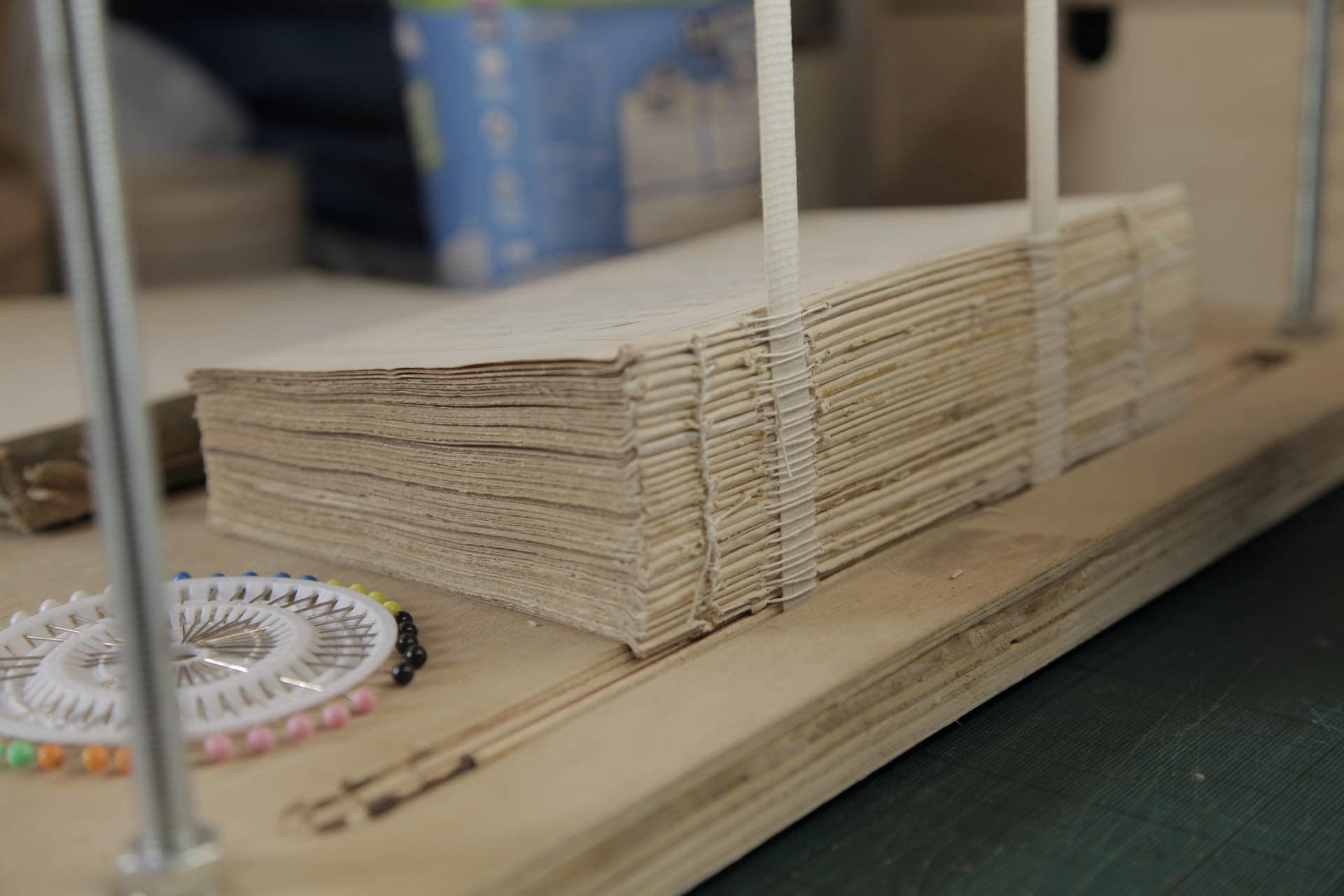 textblock on sewing frame being sewn to linen tapes